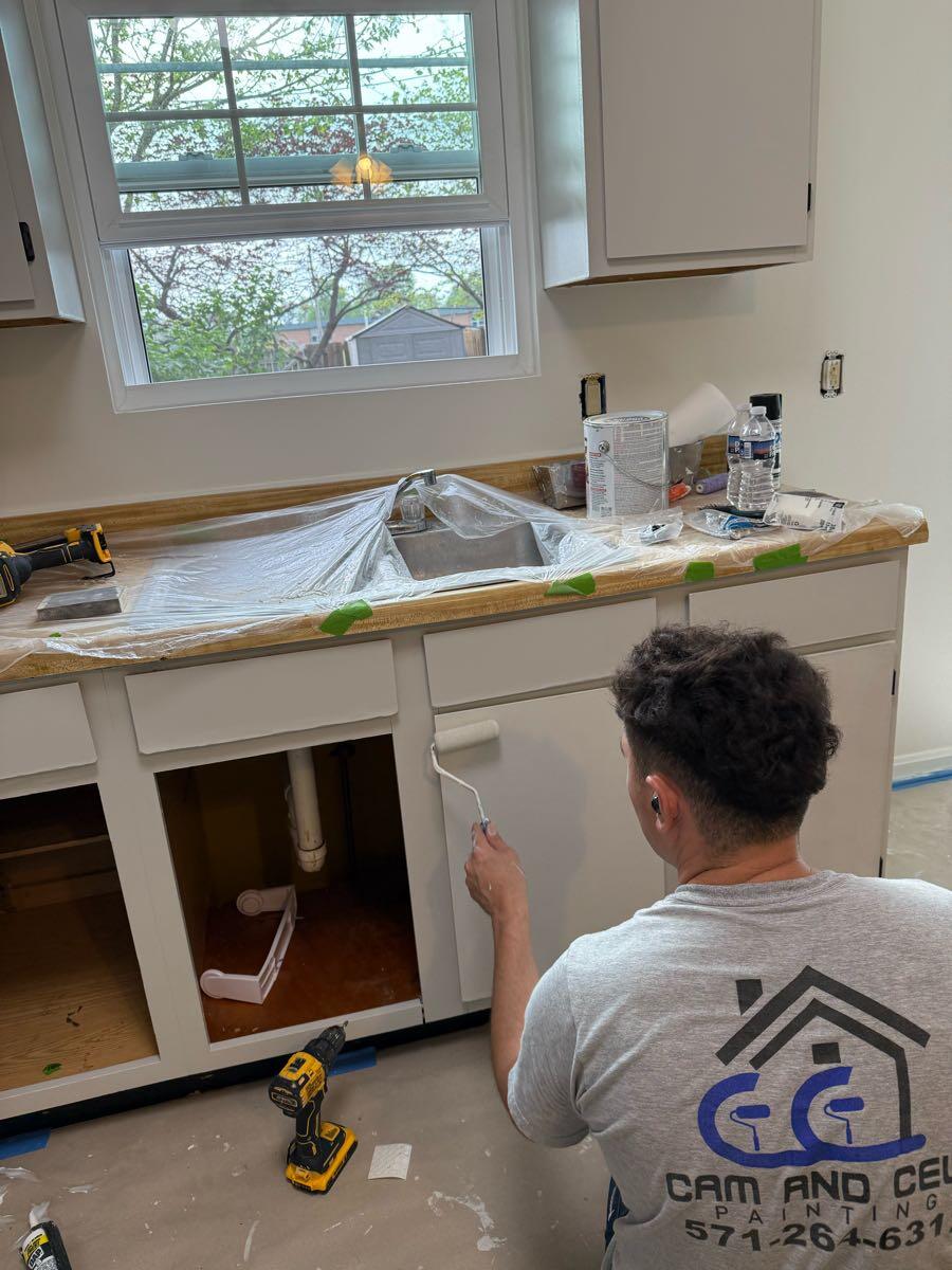 Cam and Cels team member painting a cabinet